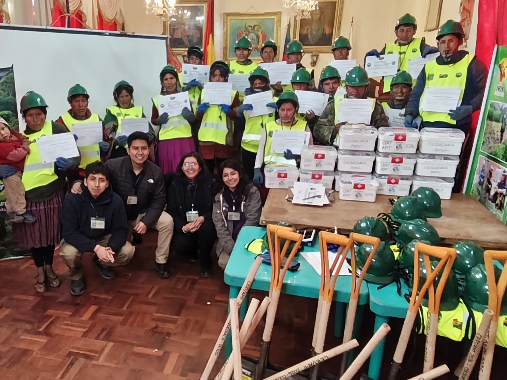 La promoción completa de CERT Colquechaca muestra sus certificados junto a los botiquines y el equipamiento comunitario entregado.