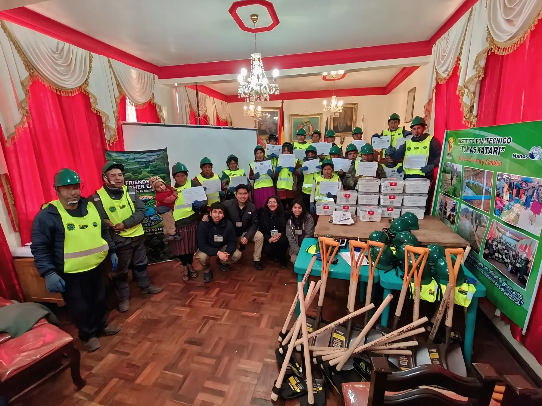 Comunidad de Colquechaca con cascos verdes y chalecos reflectivos muestra sus certificados junto al equipo de la ONG, palas y botiquines